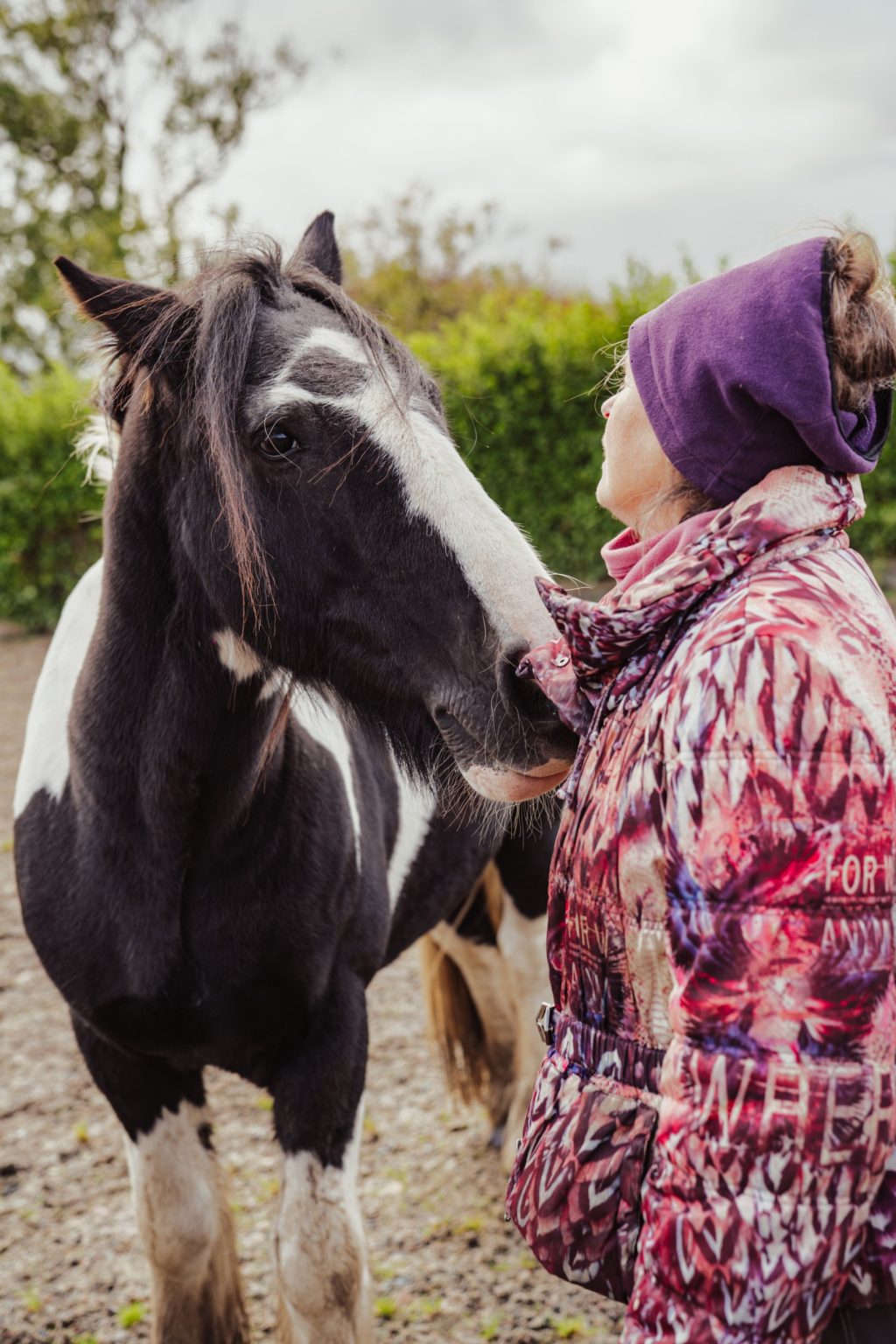 Mary close to a black and white horse